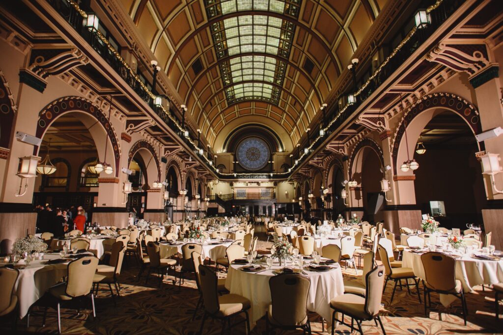 A beautifully set banquet hall with ornate architecture and ambient lighting ideal for formal events.