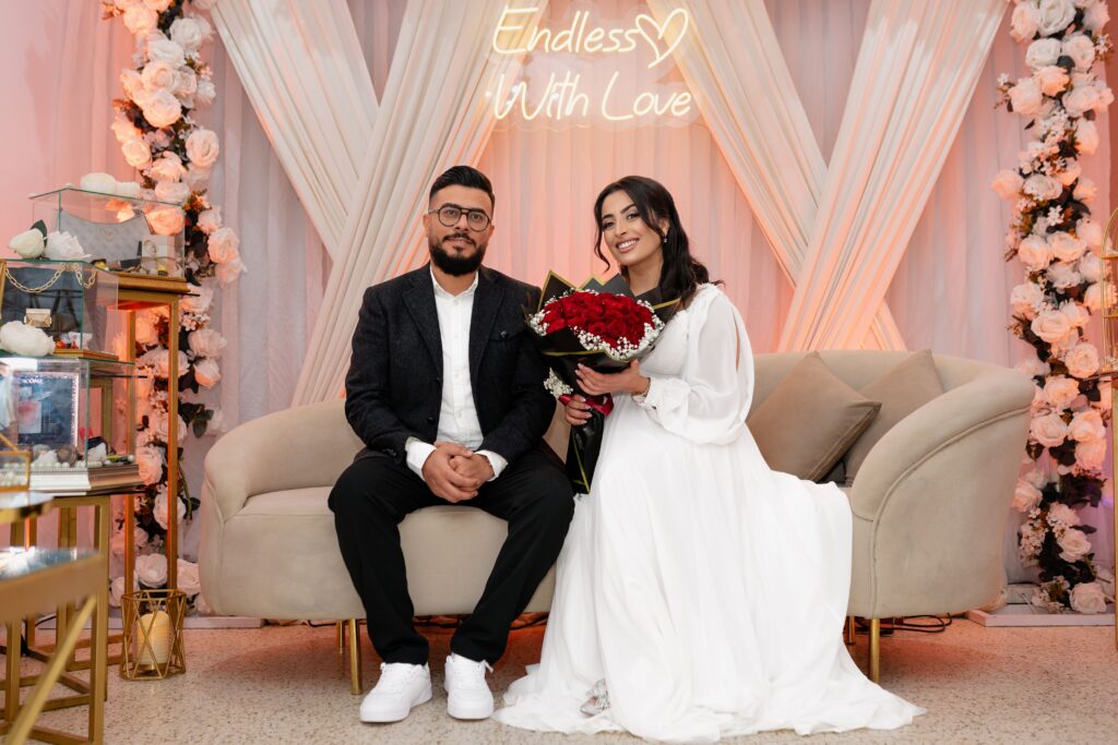 A couple celebrates their engagement with flowers and love, set in a beautiful venue.