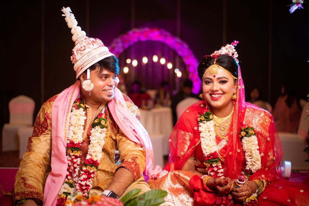 A joyful Indian bride and groom during a vibrant wedding ceremony, showcasing traditional attire and rituals.