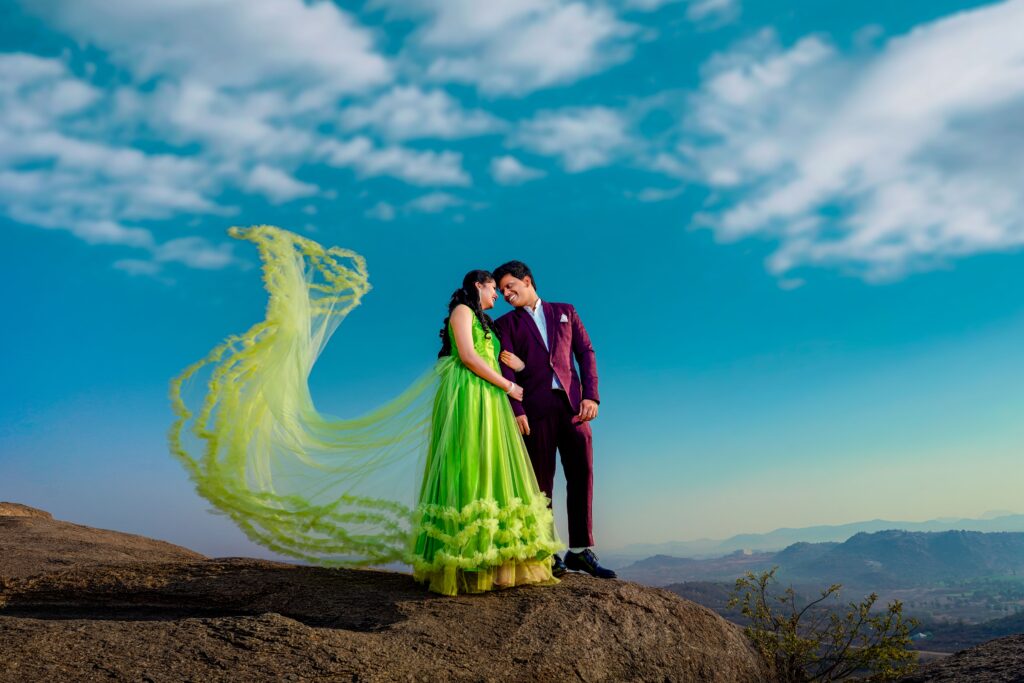 A couple posing romantically on a mountain top in India during a vibrant pre-wedding photoshoot.