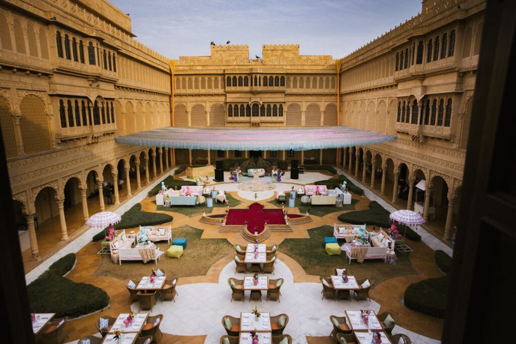 Beautiful courtyard wedding ceremony at an Indian palace with colorful decoration and seating arrangements.
