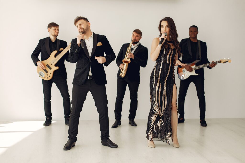 A stylish jazz band performing indoors with two vocalists and musicians in black attire.